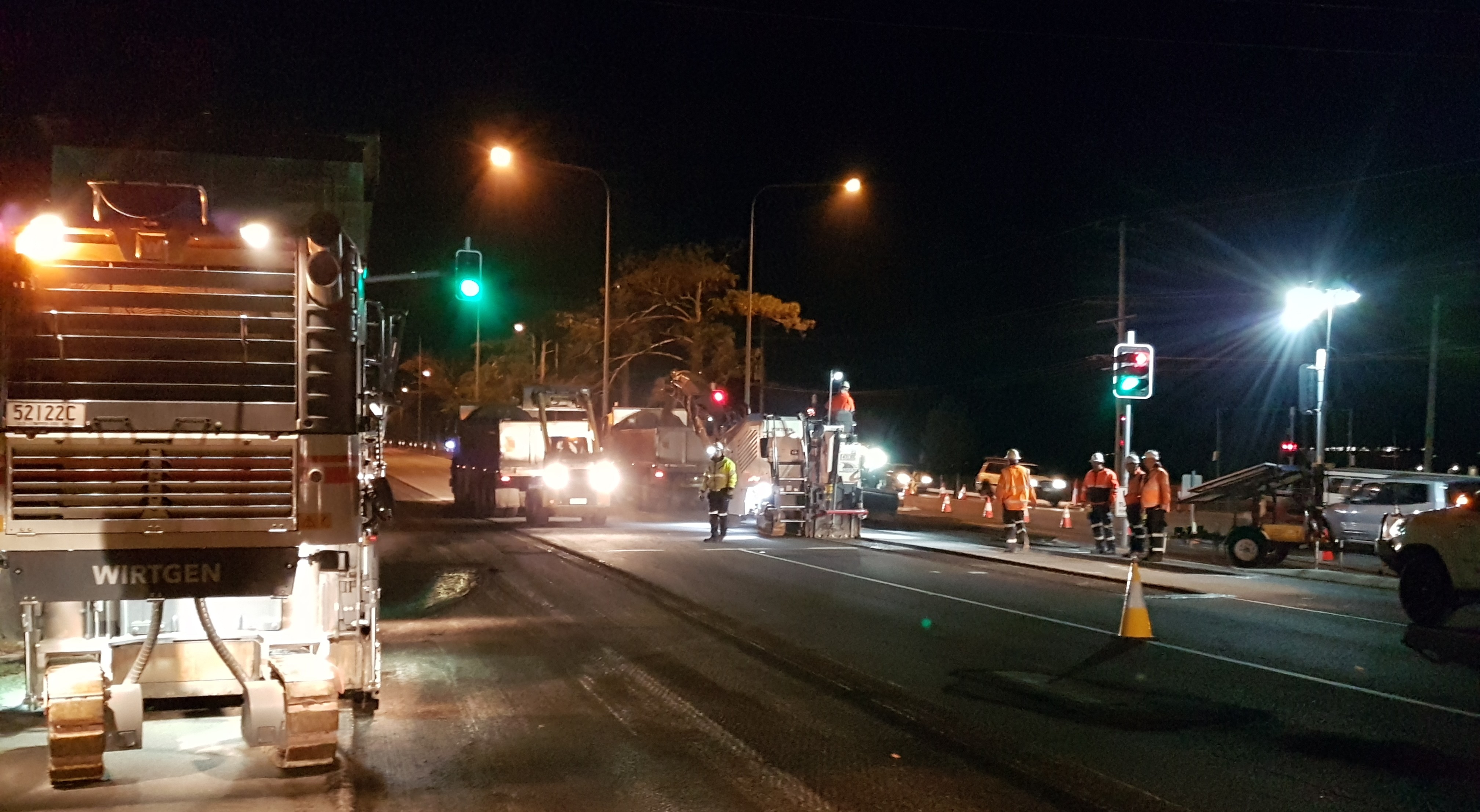 QBC night-works crew on a live arterial road - milling and repaving under traffic management